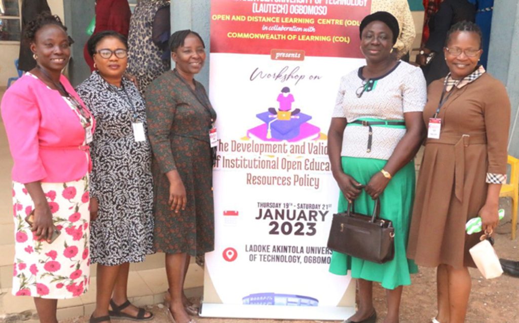 five participants pose in front of workshop banner