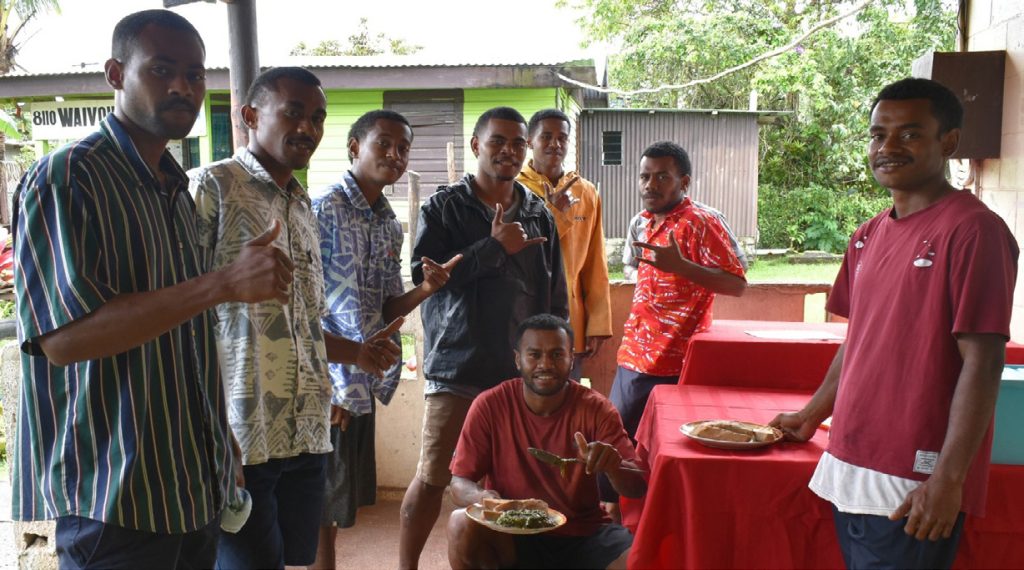 a group of young men in Tonga posing with with their thumbs up